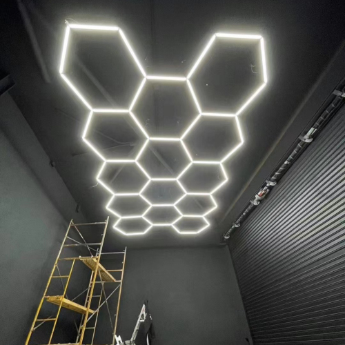 Les lumières hexagonales de logement en aluminium adaptées aux besoins du client pour le mur de lumière LED hexagonal de salle d'exposition de voiture d'école de gymnase de studio de voiture