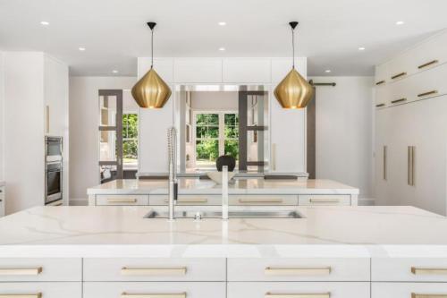 Unionlands Cabinetry White Kitchen Slab Panel With Gold Accents Two Islands with Luxury Countertops