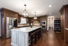 Unionlands Cabinetry Raised Panel Cherry Stain and Mullion Glass Door With White Painted Island Cabinet