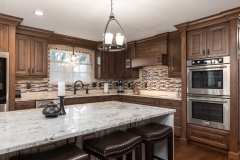 Unionlands Cabinetry Raised Panel Cherry Stain and Mullion Glass Door With White Painted Island Cabinet