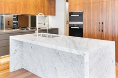 Unionlands Cabinetry Timber Veneer and Polyyurethane Kitchen Cabinet Handleless Slab Panel with a Carrara Marble Feature Island
