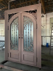Double panel wrought iron front entry door with arc top in brown color