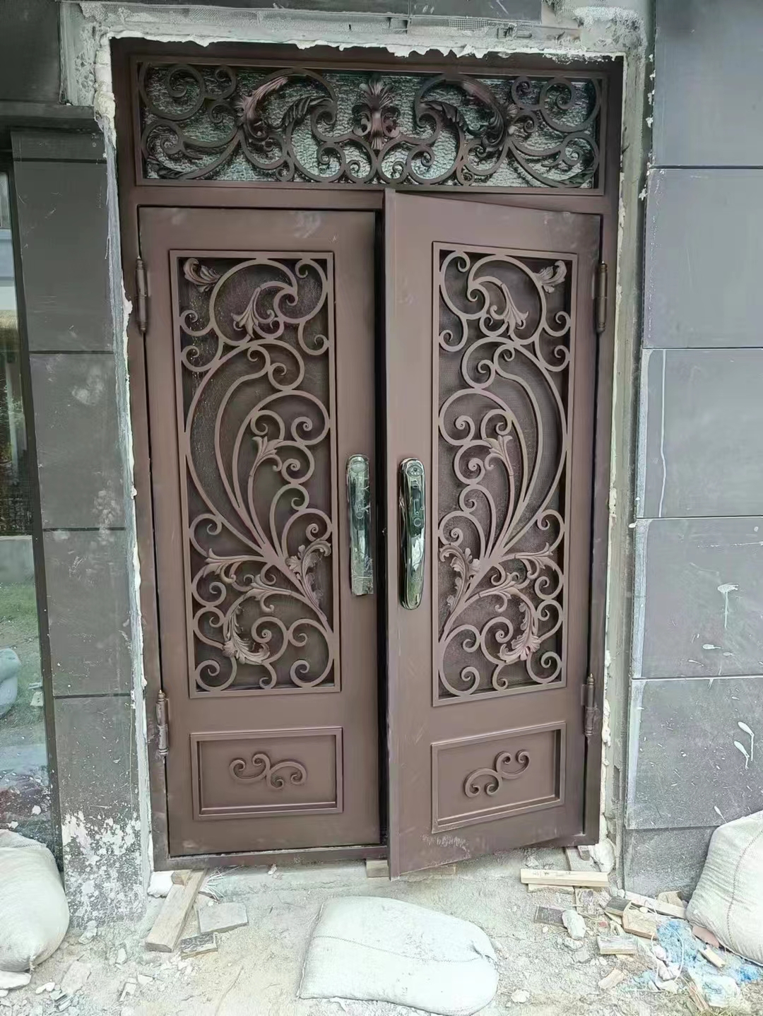 double wrought iron front door in brown color
