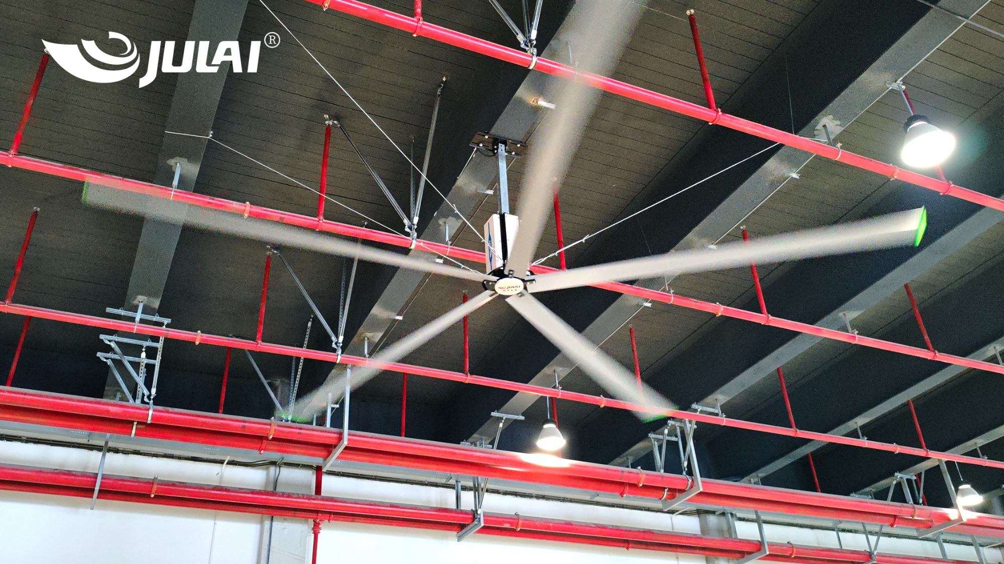Why can large industrial ceiling fans cover a vast factory area?