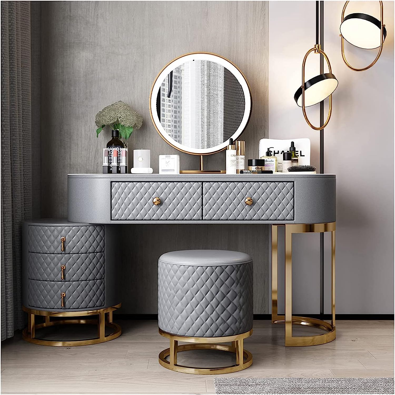 A well-decorated room featuring a round mirrored vanity with gold legs and a marble countertop.