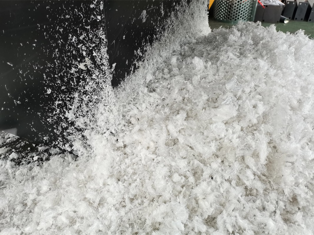 Perfectly uniform white plastic film flakes discharged from SOYU shredding machine.