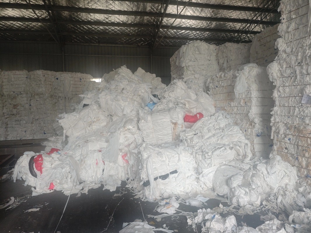 Baled waste white industrial plastic films and wrap films stacked in the recycling warehouse.
