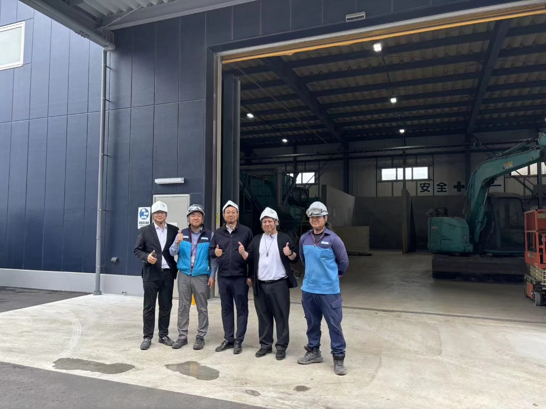 SOYU Machinery team group photo with Japanese clients in front of the smart solid waste shredding equipment, celebrating a successful project partnership.