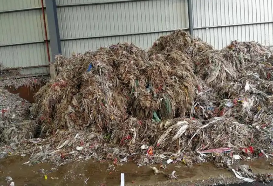 Raw industrial pulper ropes and highly contaminated paper mill ragger wire waste before shredding.