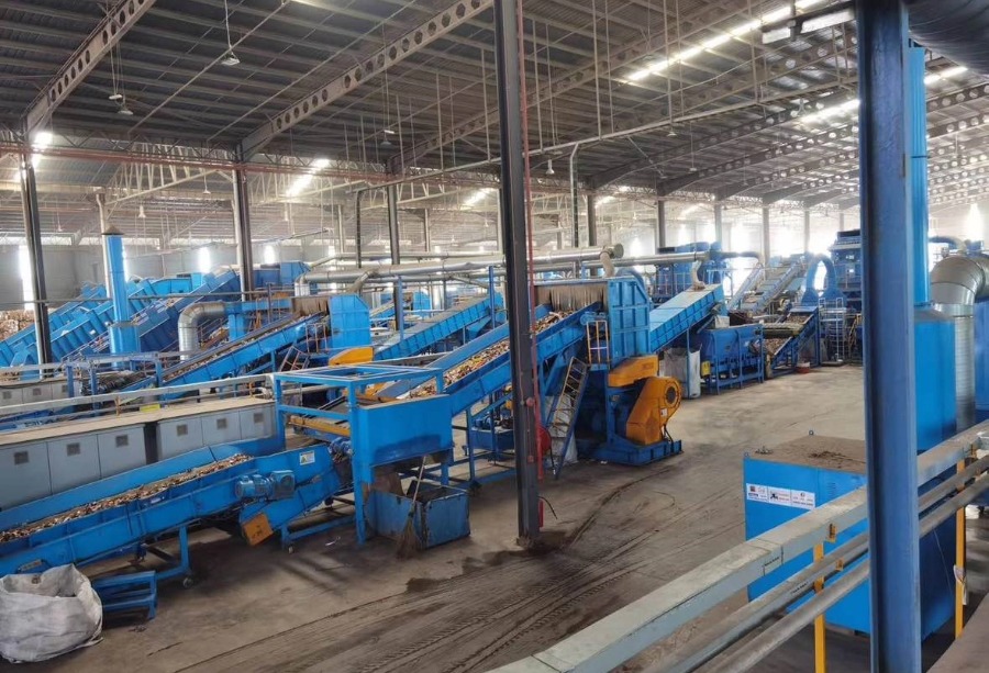 Automated solid waste sorting line with multiple belt conveyors and shredding equipment for paper mill waste.