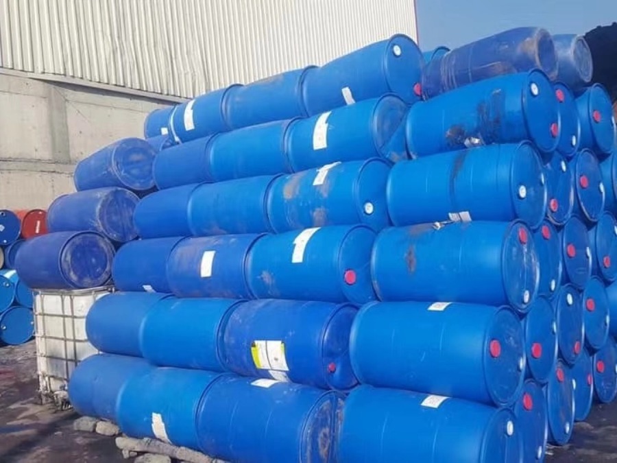 Oversized HDPE blue barrels and plastic drums stored in a recycling facility