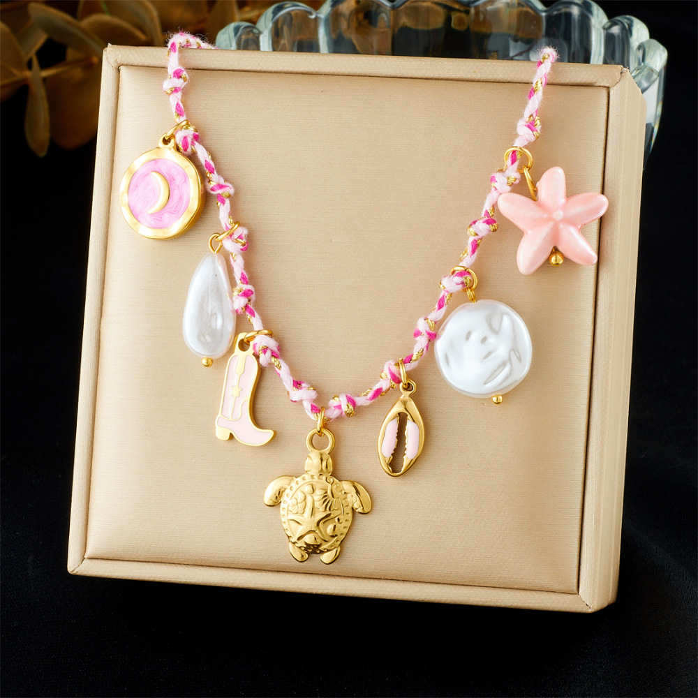 Ocean-themed stainless steel necklace with starfish, turtle, conch, and seashell motifs for women.
