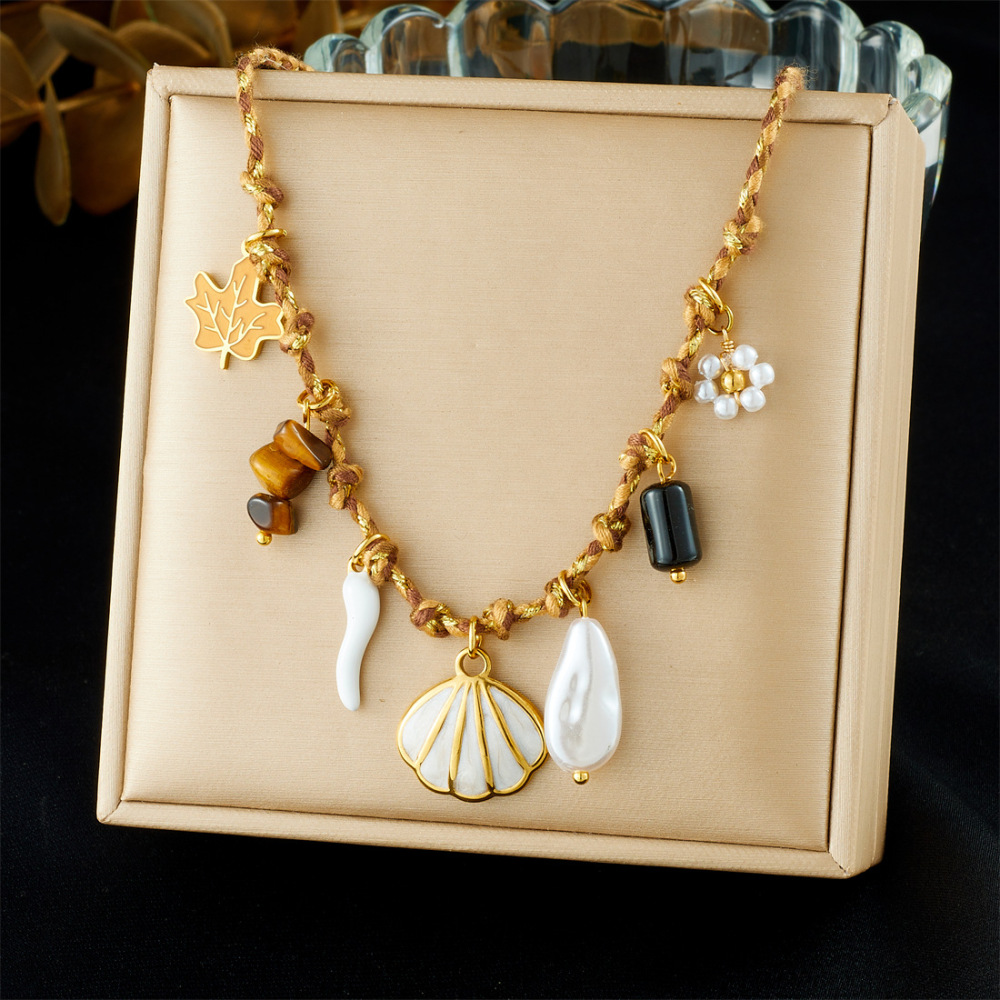 Ocean-themed stainless steel necklace with starfish, turtle, conch, and seashell motifs for women.