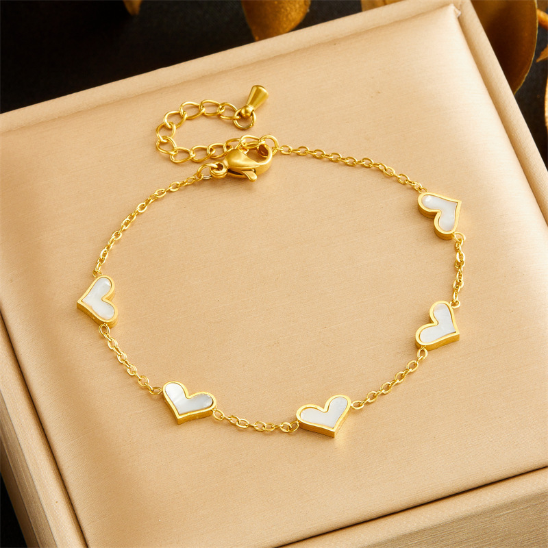 Korean style, simple and fashionable, elegant gold-plated seashell heart accessory chain stainless steel bracelet, earrings, and necklace set.