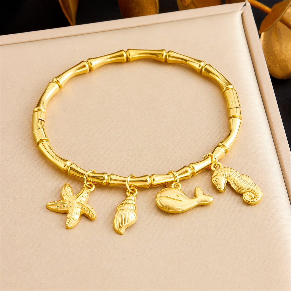Niche fashion gold-plated stainless steel premium ocean-themed accessories: tropical fish, starfish, butterfly, conch, bamboo bracelet.