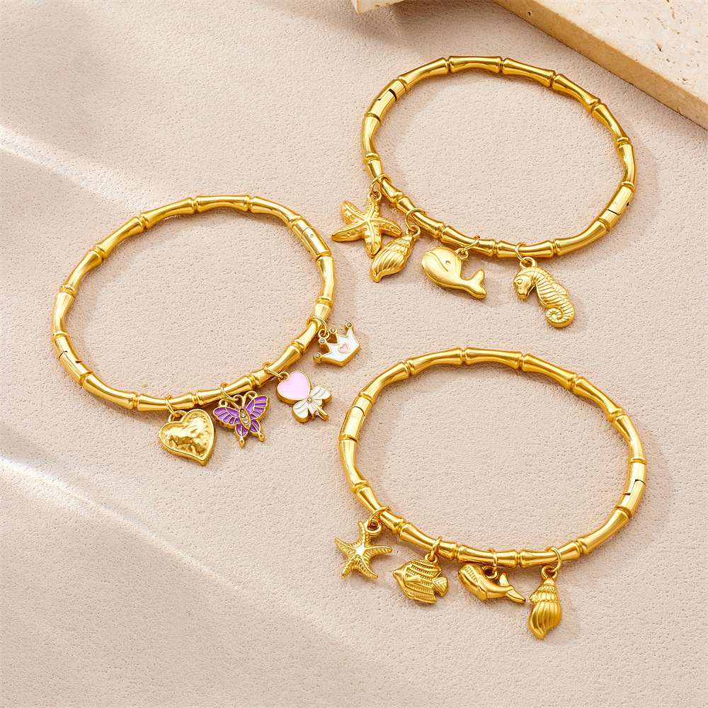 Niche fashion gold-plated stainless steel premium ocean-themed accessories: tropical fish, starfish, butterfly, conch, bamboo bracelet.