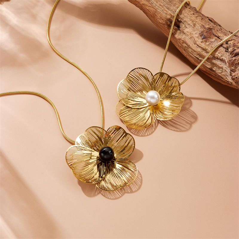 Stylish and elegant pearl necklace, earrings, and ring set featuring openwork petals and a pearl design.