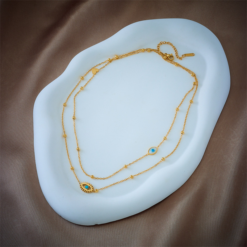 European and American niche fashion design double-layer mixed chain gold bead titanium steel drip oil hollow blue eye pendant necklace