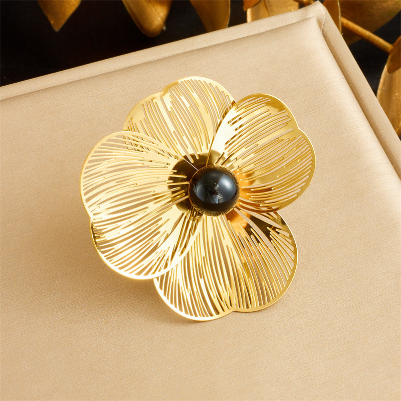 Stylish and elegant pearl necklace, earrings, and ring set featuring openwork petals and a pearl design.