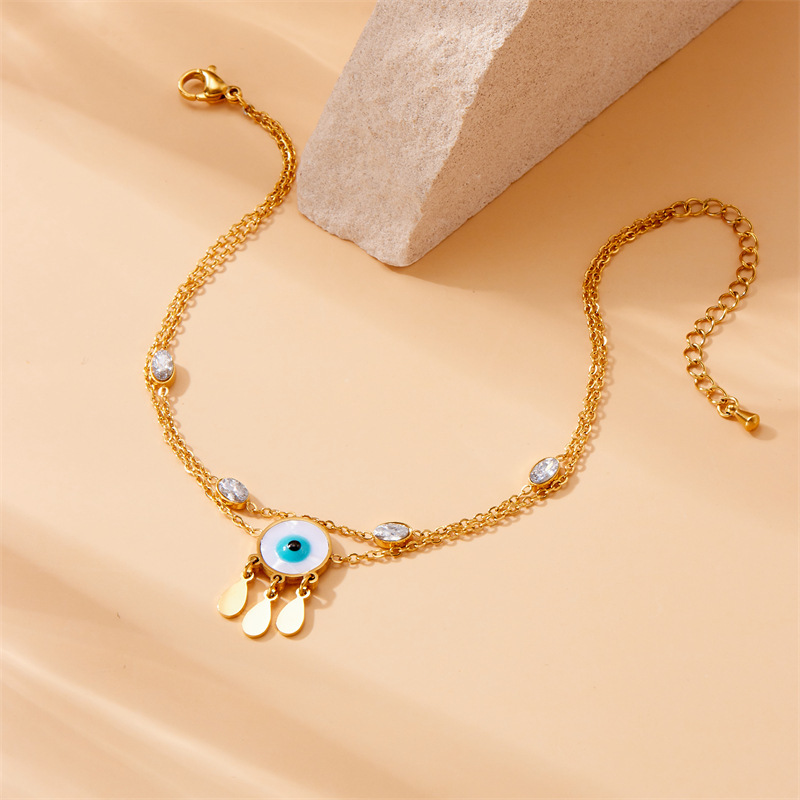 European and American style niche personalized double-layered stainless steel anklet with small flower eyes, teardrop design, rhinestone tassels.
