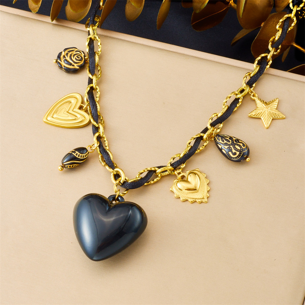 Niche fashion design with multi-element sculpted floral geometric pendant, gold-plated black heart accessory necklace.
