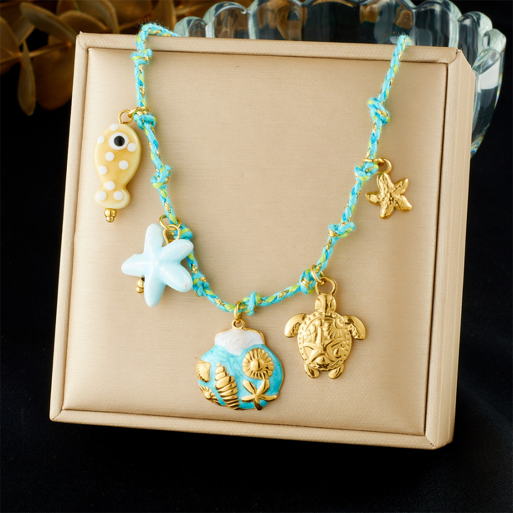 Ocean-themed stainless steel necklace with starfish, turtle, conch, and seashell motifs for women.