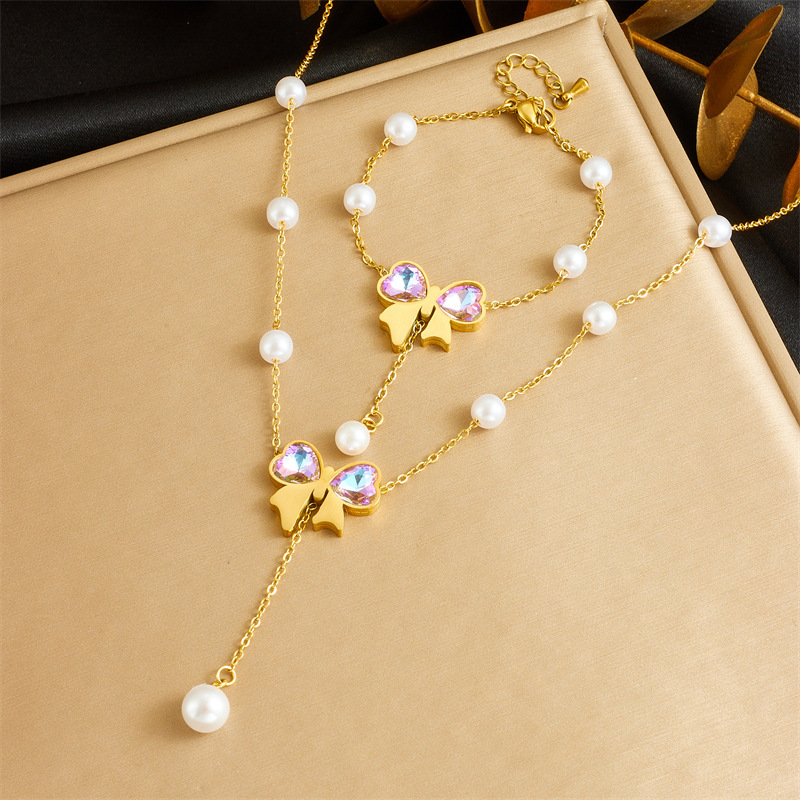 Cross-border fashion dazzling rhinestone bow gold-plated pearl chain stainless steel tassel pendant necklace and bracelet set