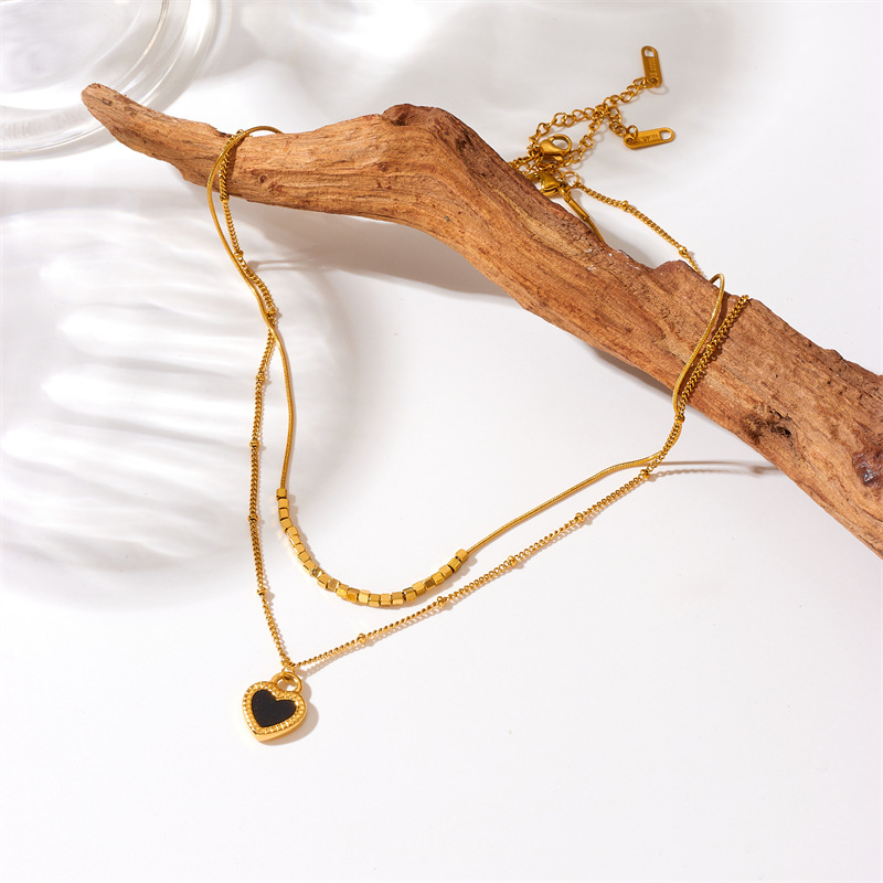 European and American style, simple and versatile, heart-shaped gold-plated titanium steel double-layer chain necklace with black and white heart pendant.