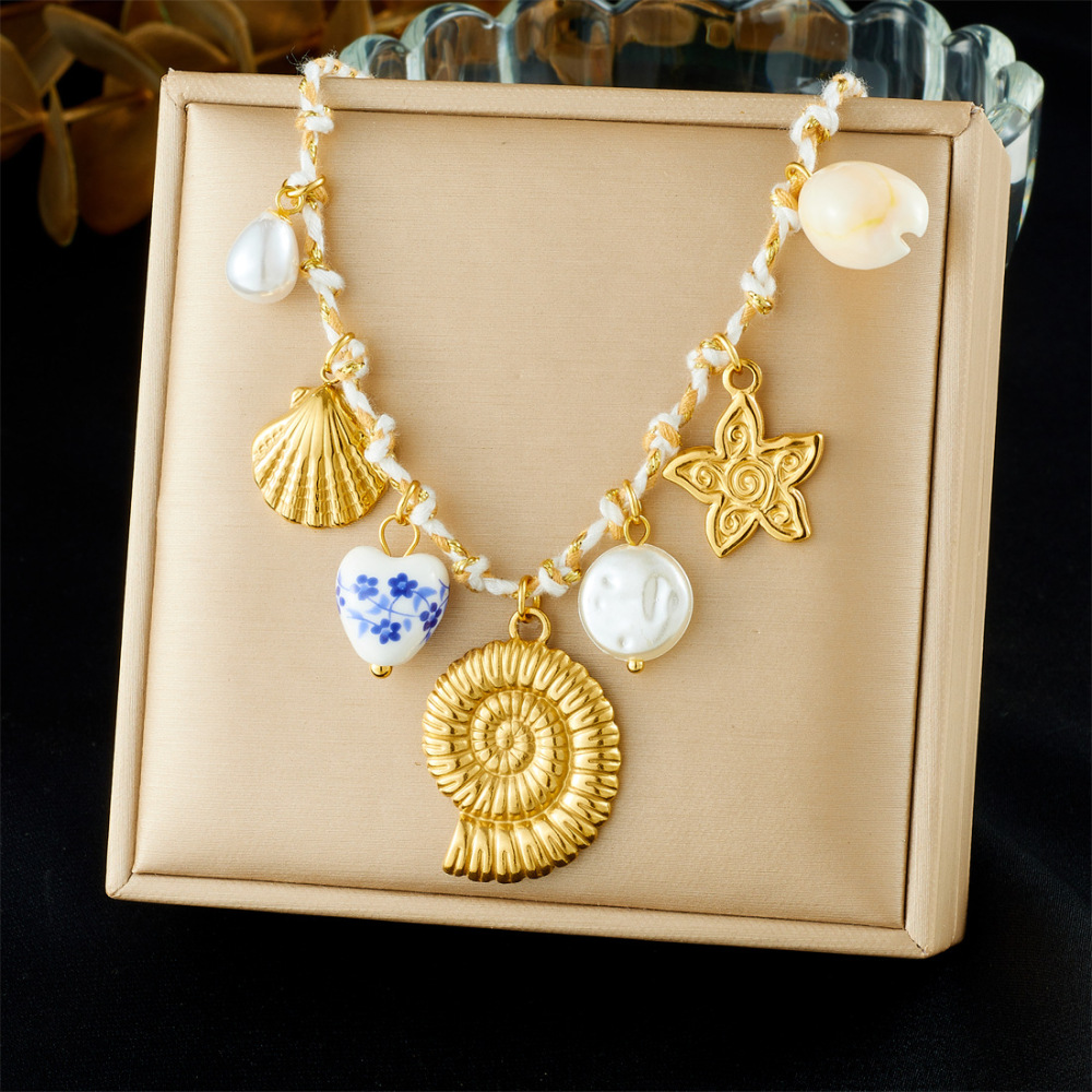 Ocean-themed stainless steel necklace with starfish, turtle, conch, and seashell motifs for women.