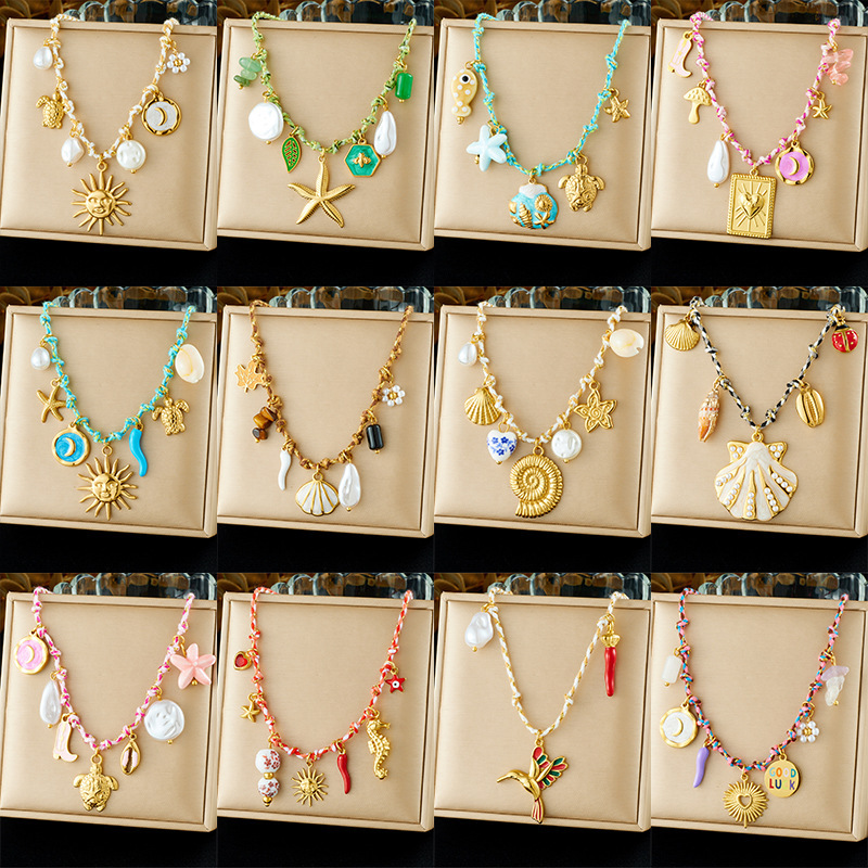 Ocean-themed stainless steel necklace with starfish, turtle, conch, and seashell motifs for women.