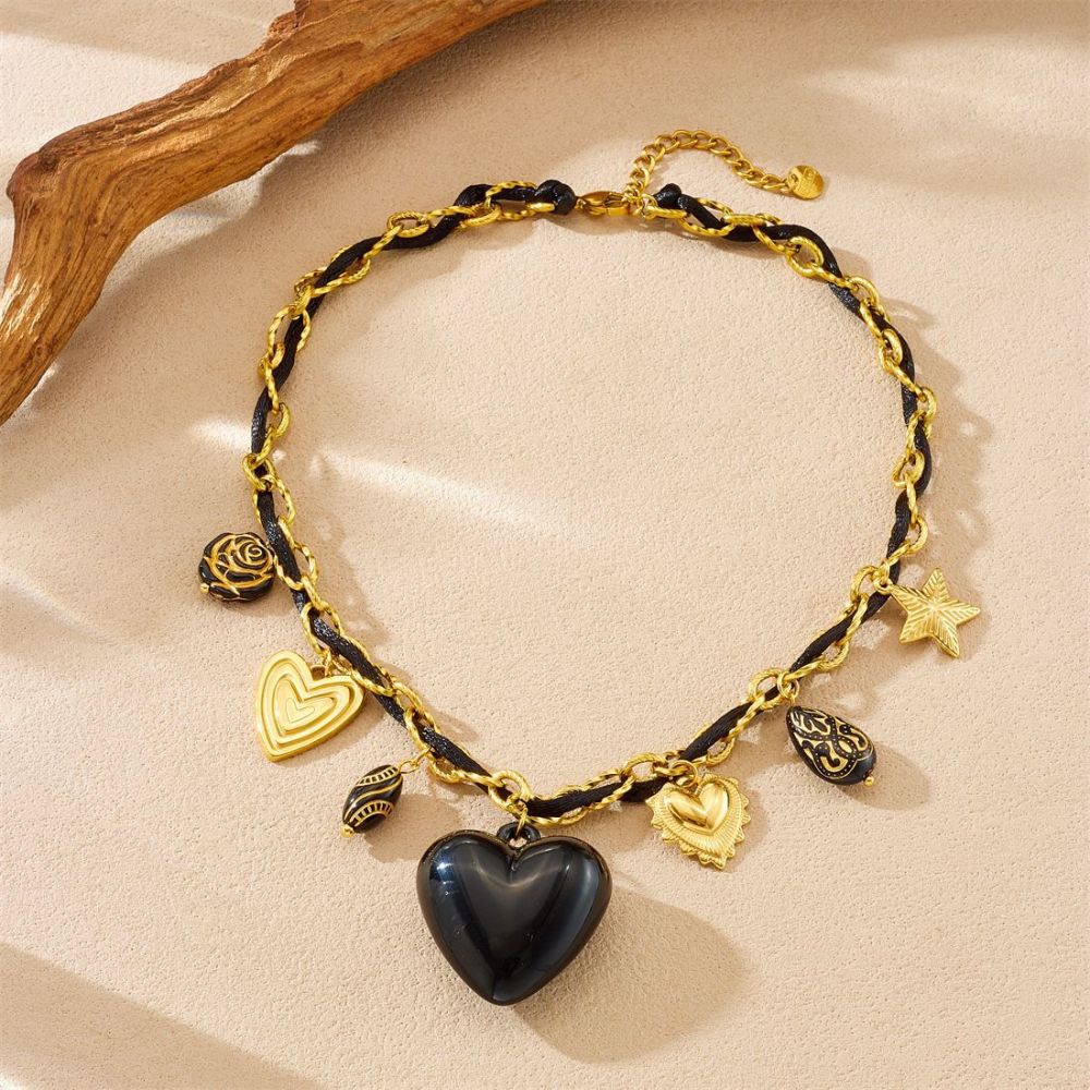 Niche fashion design with multi-element sculpted floral geometric pendant, gold-plated black heart accessory necklace.