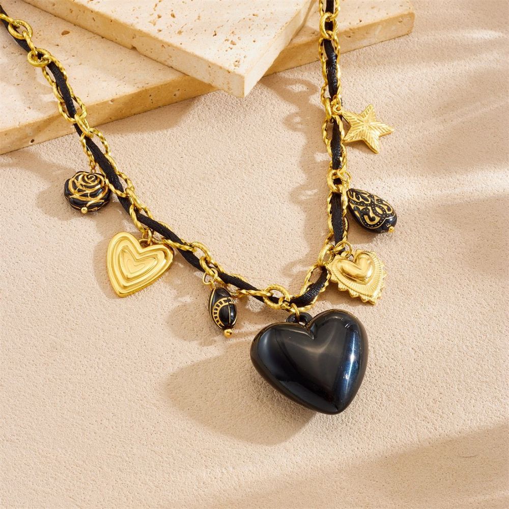Niche fashion design with multi-element sculpted floral geometric pendant, gold-plated black heart accessory necklace.