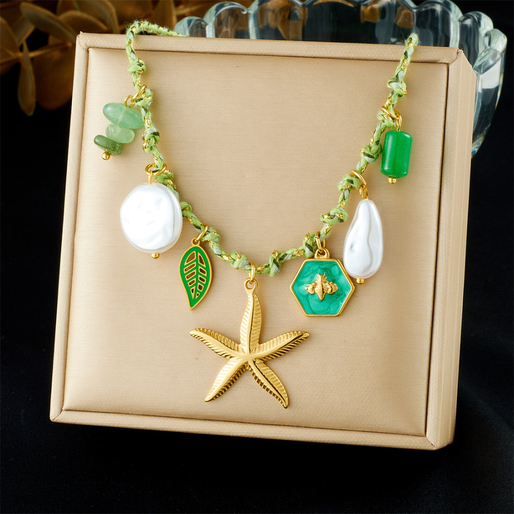 Ocean-themed stainless steel necklace with starfish, turtle, conch, and seashell motifs for women.