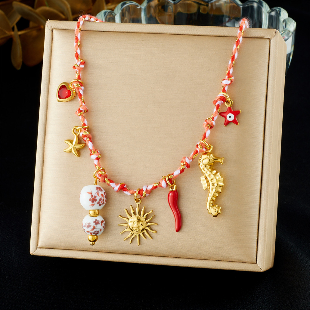 Ocean-themed stainless steel necklace with starfish, turtle, conch, and seashell motifs for women.