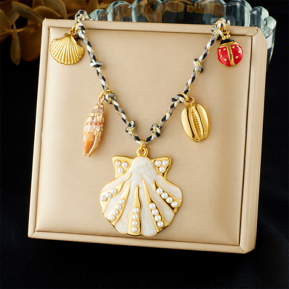 Ocean-themed stainless steel necklace with starfish, turtle, conch, and seashell motifs for women.