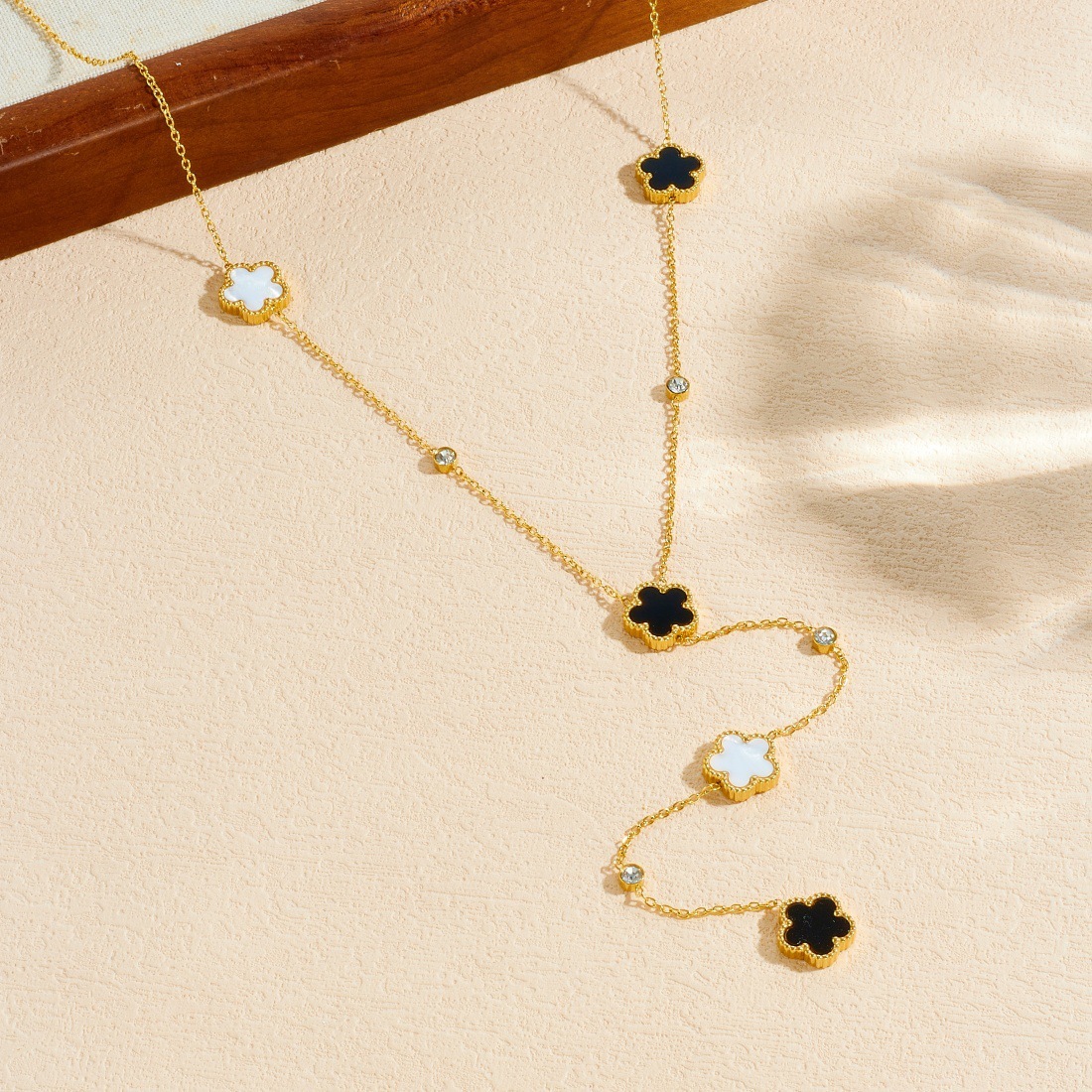 Korean style, fashionable, minimalist, black and white double-sided flower pendant long Y-shaped tassel stainless steel gold-plated necklace.