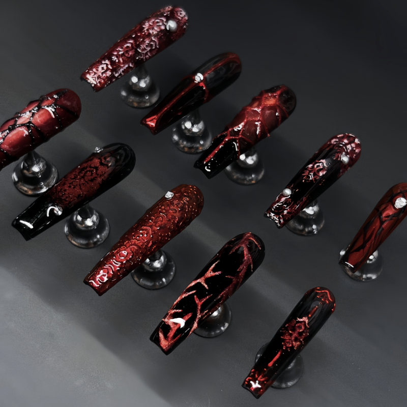 Forbidden Love gothic burgundy nails in natural daylight showing black lace motifs and metallic rose accents