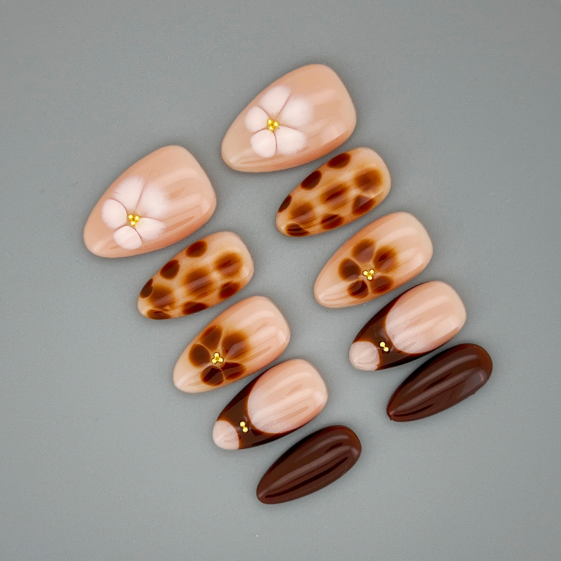 Close up of Auburn Petal almond nail highlighting glossy finish and warm red‑brown pigment
