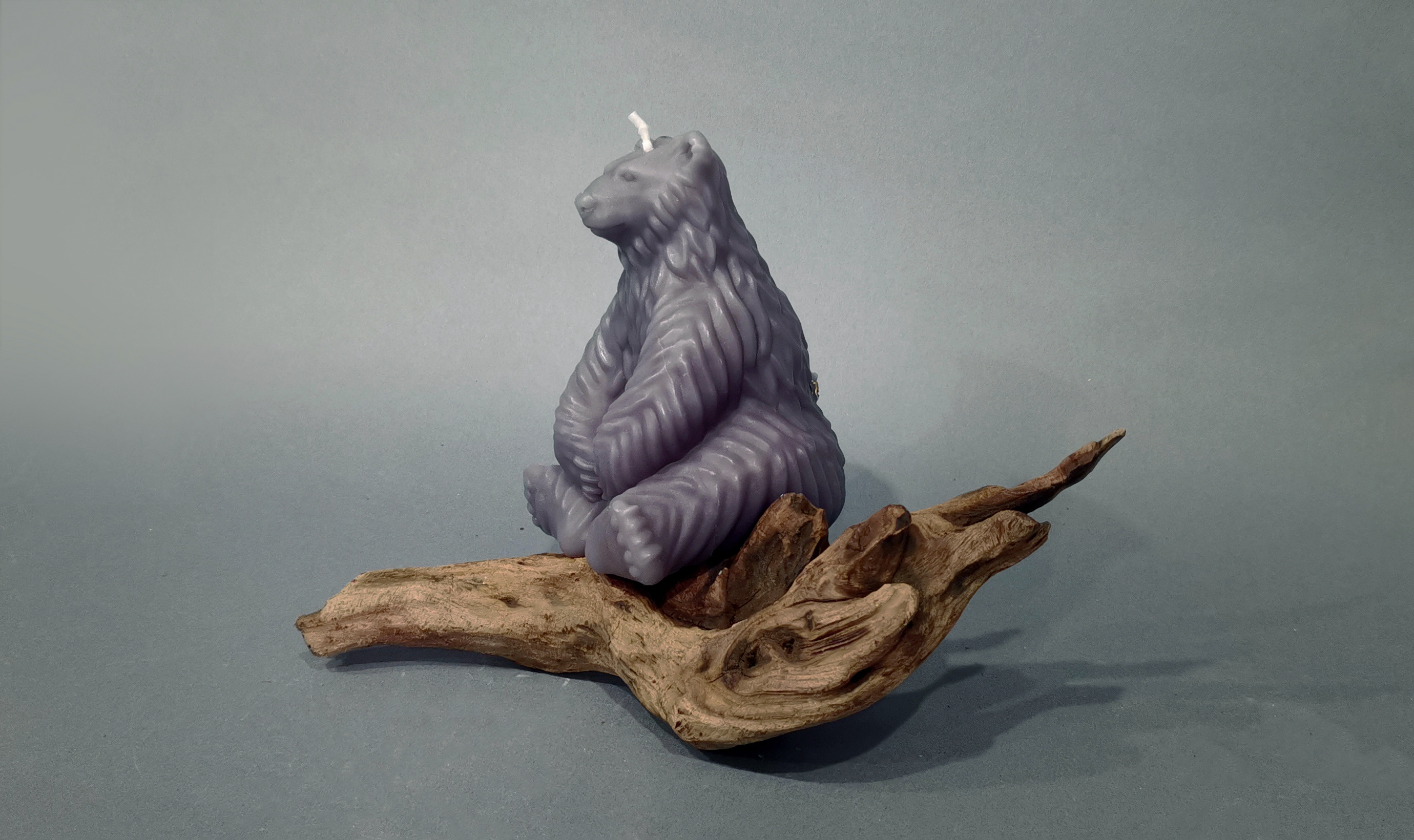 Gray Polar Bear Candle sitting on  a piece of wood_horizontal