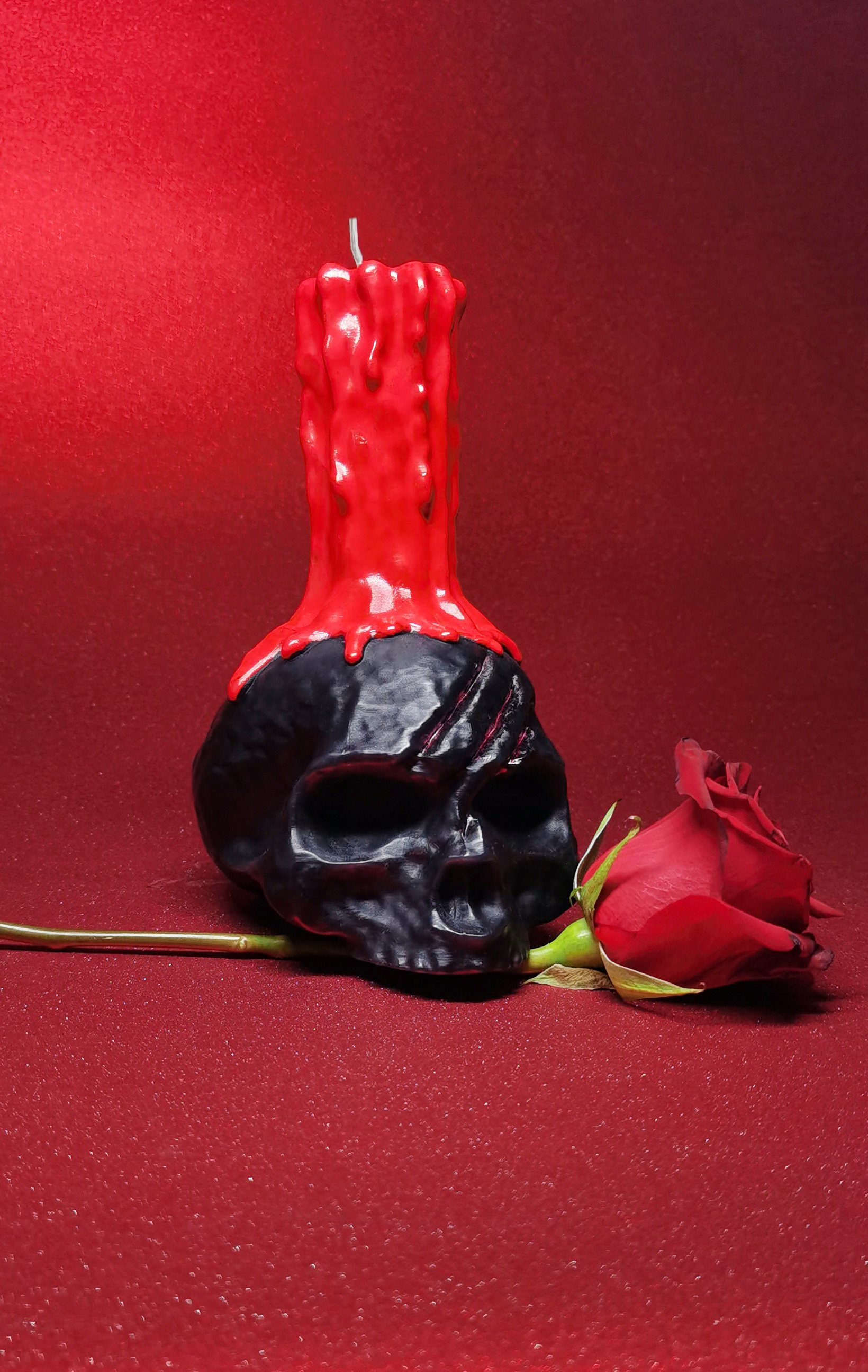 Gothic Skull Candle with Red Dripping Pillar_biting a red rose in red background