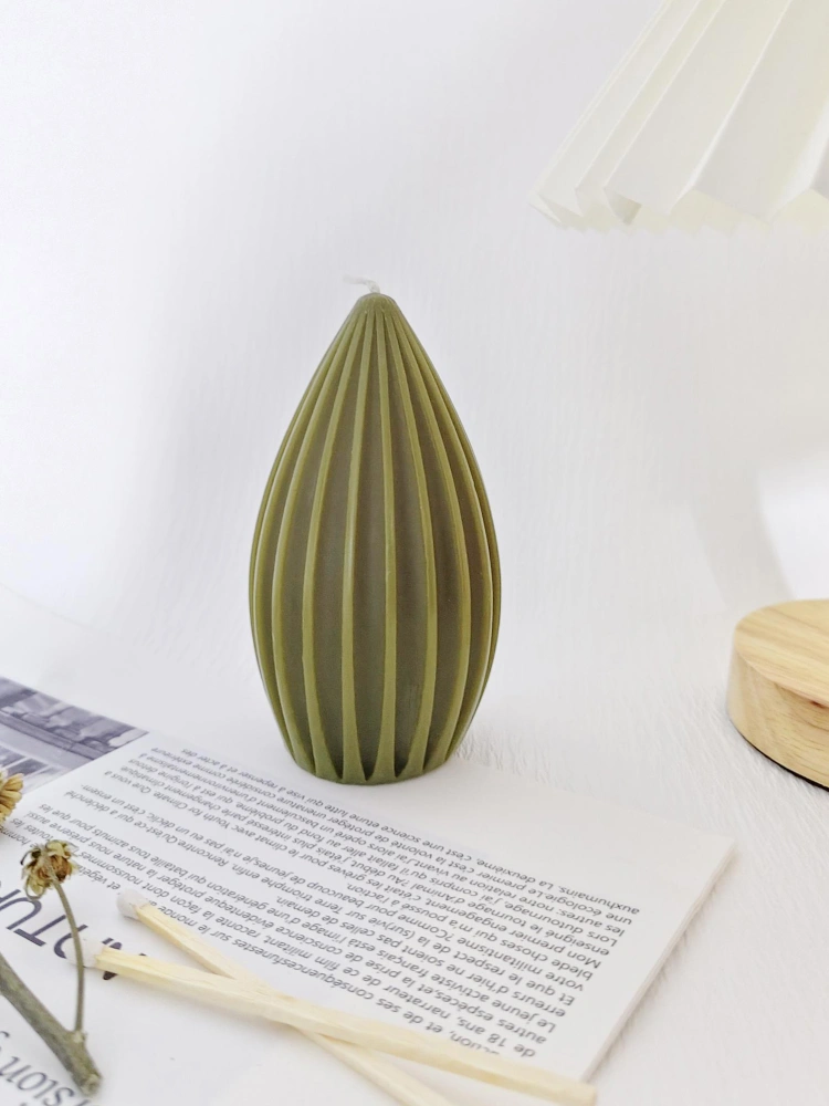 Olive green geometric candle in a natural setting