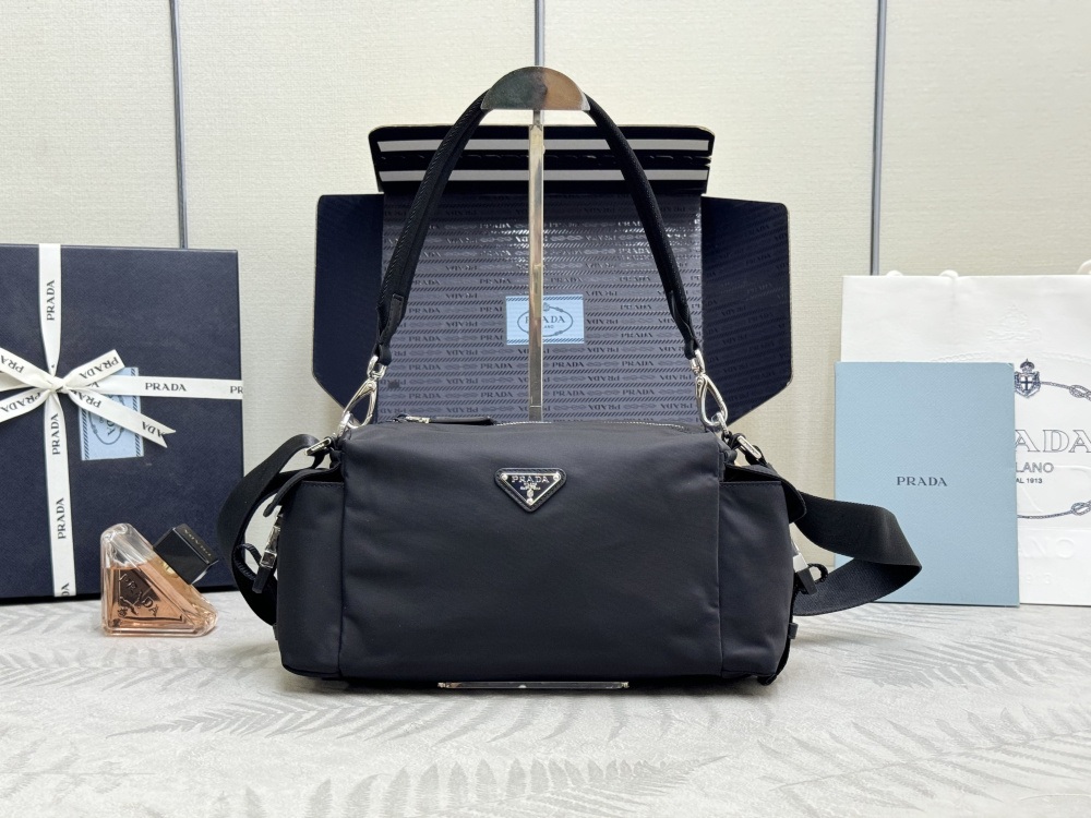 alt="Prada黑色Re-Nylon探索包，配銀色三角徽標"