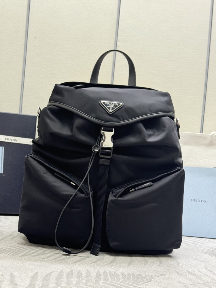 alt="Prada黑色Re-Nylon雙肩包，配銀色三角徽標"