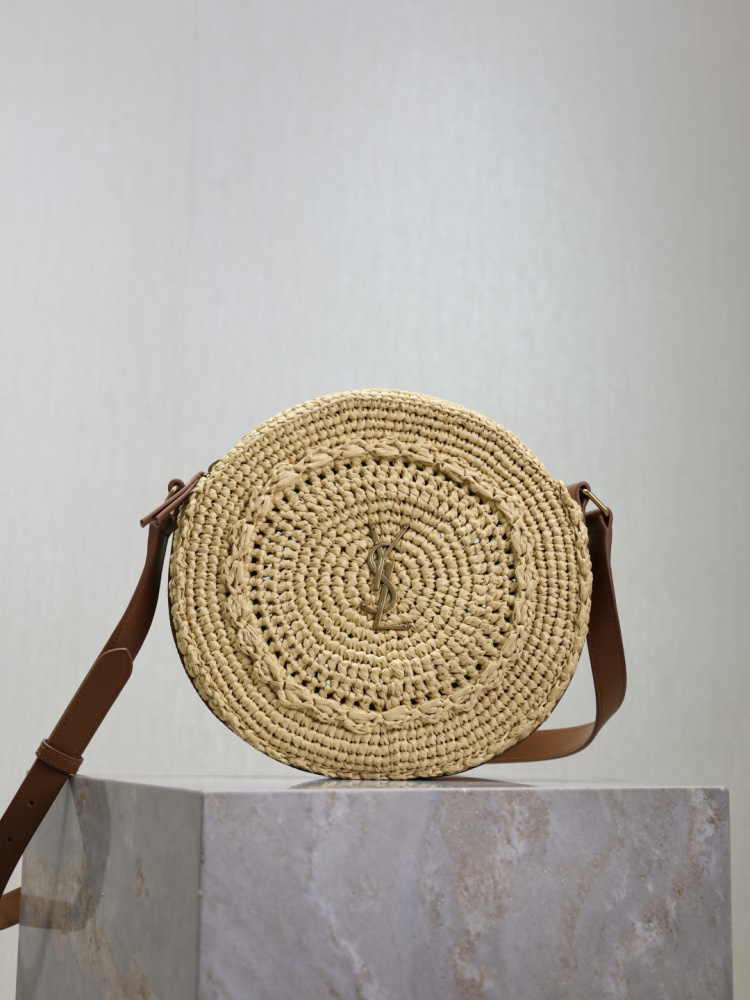 alt="Saint Laurent Round Raffia Bag，米色圓形拉菲草編織，搭配棕色皮革肩帶與金色YSL Logo"