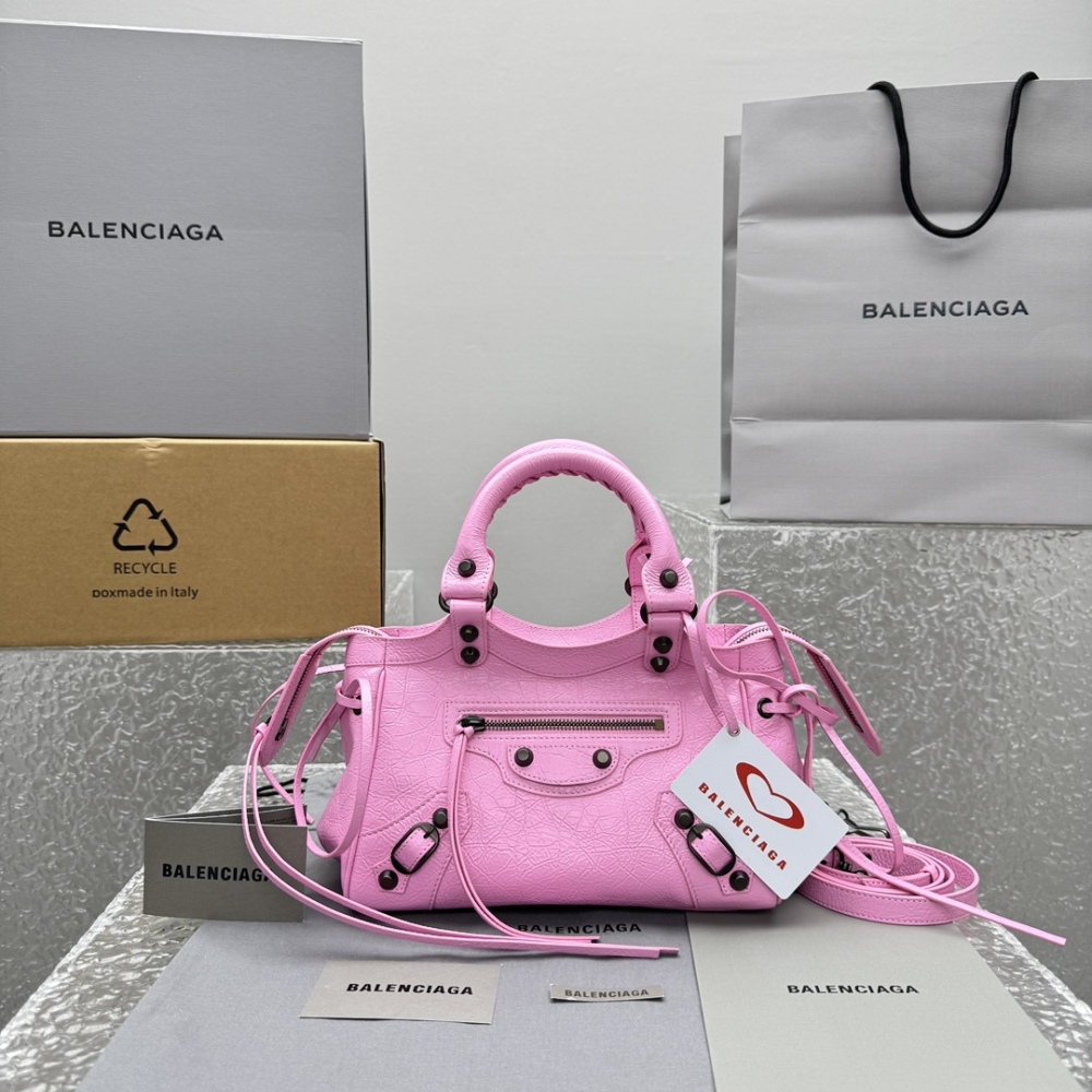 alt="巴黎世家 Le City 粉色机车包与品牌包装盒、购物袋"