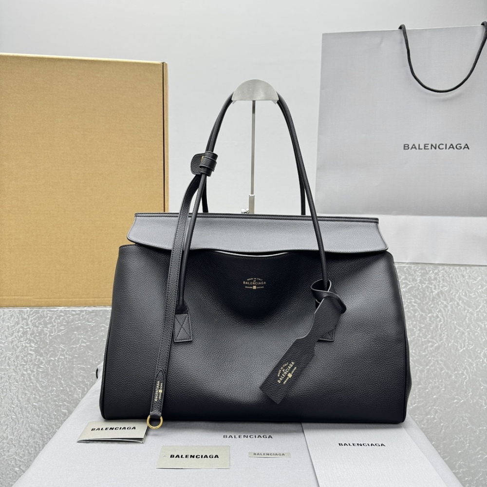 alt="巴黎世家 Carrie Carry All 黑色托特包，搭配品牌包装盒与购物袋"