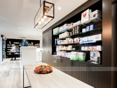 White Pharmacy Reception Counter with Dark Wall Shelves
