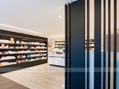 White Pharmacy Reception Counter with Dark Wall Shelves