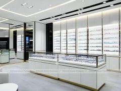 Glossy White Eyewear Boutique Interior with Gold Accent Counter
