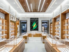 Warm Walnut Vision Store Interior with Symmetrical Display Corridor